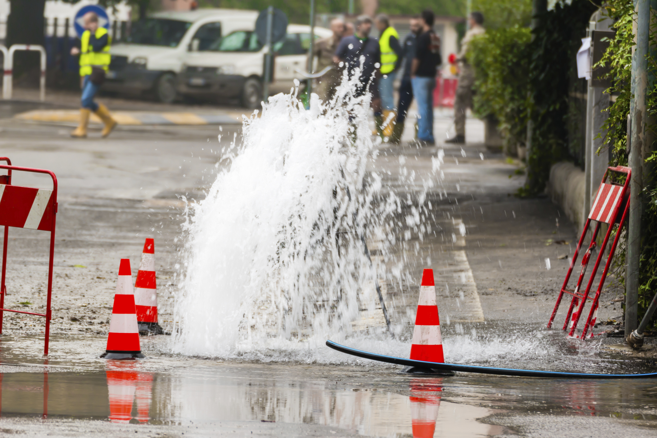 utilities road spurt water beside traffic cones